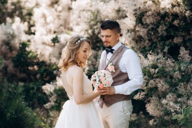 Gelin ve damat parklarda yürüyorlar patikalar boyunca ve ışık huzmeleri içinde