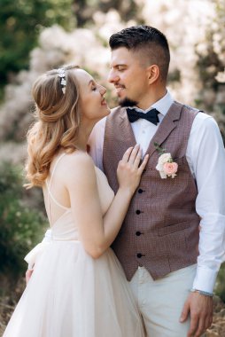 Gelin ve damat parklarda yürüyorlar patikalar boyunca ve ışık huzmeleri içinde