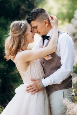 Gelin ve damat parklarda yürüyorlar patikalar boyunca ve ışık huzmeleri içinde