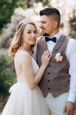 Gelin ve damat parklarda yürüyorlar patikalar boyunca ve ışık huzmeleri içinde