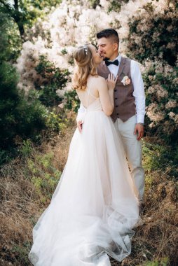 Gelin ve damat parklarda yürüyorlar patikalar boyunca ve ışık huzmeleri içinde