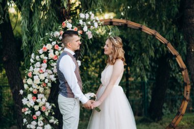 Ormandaki yeşil bir çayırda aşık genç bir çiftin düğün töreni.