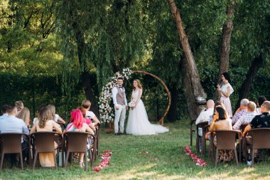 Ormandaki yeşil bir çayırda aşık genç bir çiftin düğün töreni.