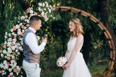 Ormandaki yeşil bir çayırda aşık genç bir çiftin düğün töreni.