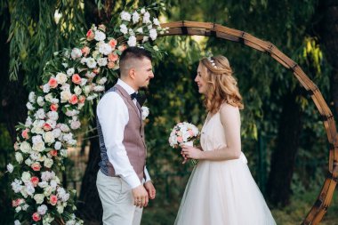 Ormandaki yeşil bir çayırda aşık genç bir çiftin düğün töreni.