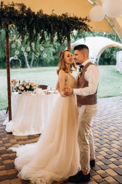 Gelin ve damadın ilk düğün dansı gün batımında restoranın içinde.