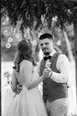 Gelin ve damadın ilk düğün dansı gün batımında restoranın içinde.