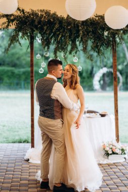 Gelin ve damadın ilk düğün dansı gün batımında restoranın içinde.