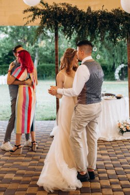 Gelin ve damadın ilk düğün dansı gün batımında restoranın içinde.