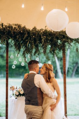 Gelin ve damadın ilk düğün dansı gün batımında restoranın içinde.