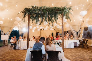 Yeni evlilerin portresi düğün şöleninde başkanlık makamında.