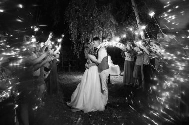 newlyweds at a wedding in the corridor of sparklers