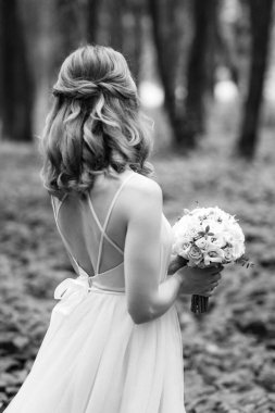 Yeşil bir bahar ormanında açık mercan elbiseli sarışın gelin.