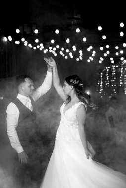 Gelin ve damadın ilk düğün dansı gün batımında restoranın içinde.