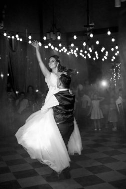 Gelin ve damadın ilk düğün dansı gün batımında restoranın içinde.