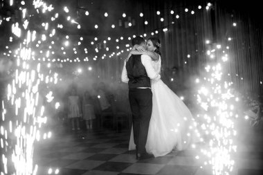 Gelin ve damadın ilk düğün dansı gün batımında restoranın içinde.