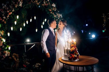 newlyweds happily cut, laugh and taste the wedding cake