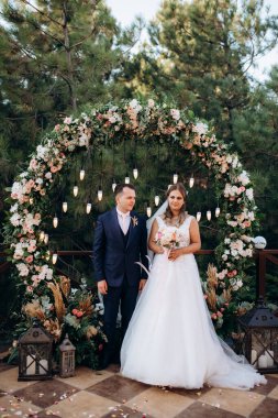 wedding ceremony of the newlyweds on the glade near the restaurant