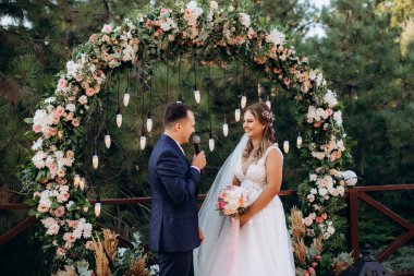 wedding ceremony of the newlyweds on the glade near the restaurant
