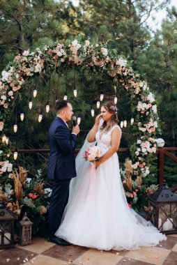 wedding ceremony of the newlyweds on the glade near the restaurant
