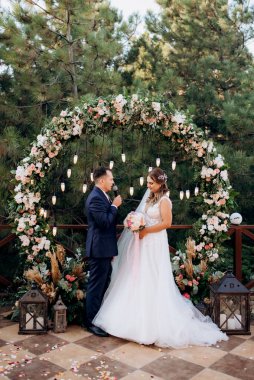 wedding ceremony of the newlyweds on the glade near the restaurant
