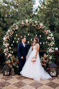 wedding ceremony of the newlyweds on the glade near the restaurant