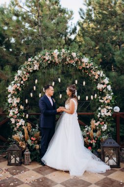 wedding ceremony of the newlyweds on the glade near the restaurant
