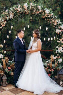 wedding ceremony of the newlyweds on the glade near the restaurant