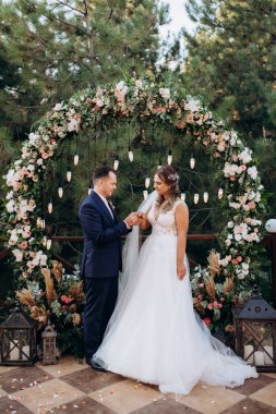 wedding ceremony of the newlyweds on the glade near the restaurant