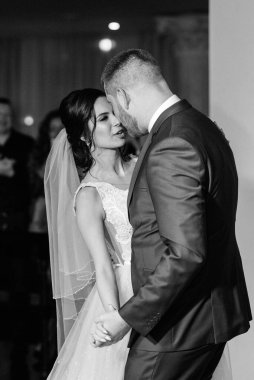 Gelin ve damadın ilk düğün dansı gün batımında restoranın içinde.