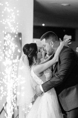 Gelin ve damadın ilk düğün dansı gün batımında restoranın içinde.