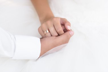 Damat gelinin elini tutar.