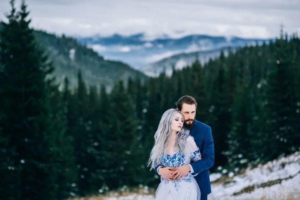 Noivo em um terno azul e noiva em branco nas montanhas Carpath — Fotografia de Stock