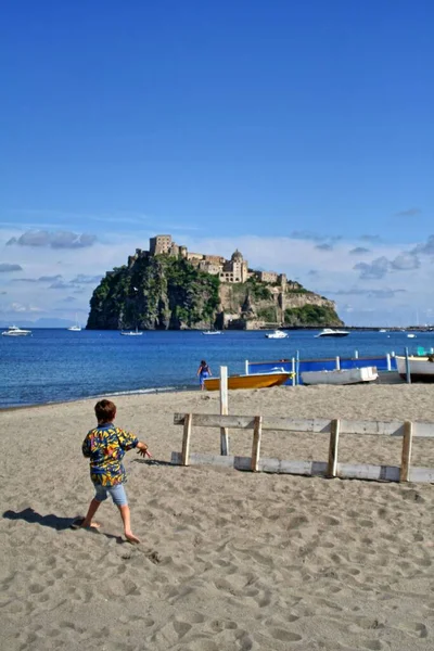 Ponte ischia plajı, ishal adası, campania, İtalya, arka planda aragonez kalesi, ön planda küçük bir çocuk.,