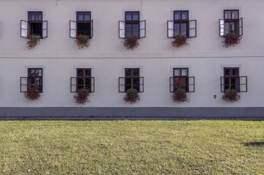 Çiçek saksılarıyla süslenmiş açık pencereler