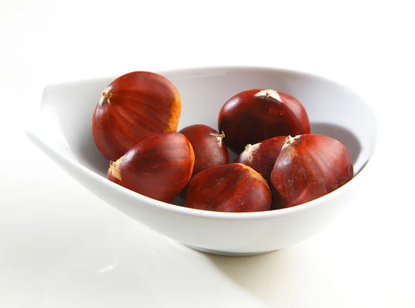 Sweet chestnuts in a white bowl Stock Picture