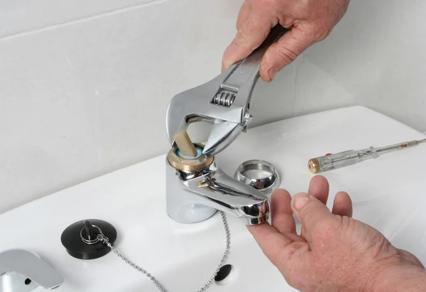 Tesisatçı bir lavabo musluk tamiri.