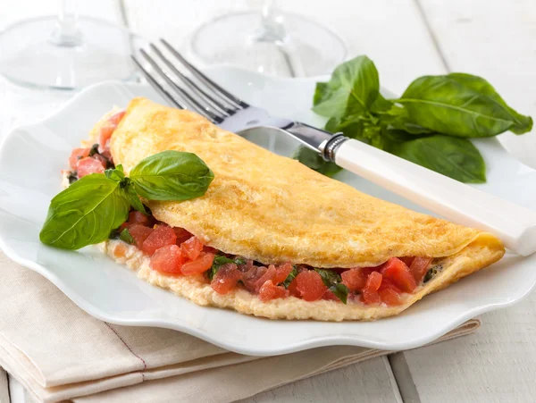 Delicioso omelete estilo italiano cheio de tomate e manjericão . — Fotografia de Stock