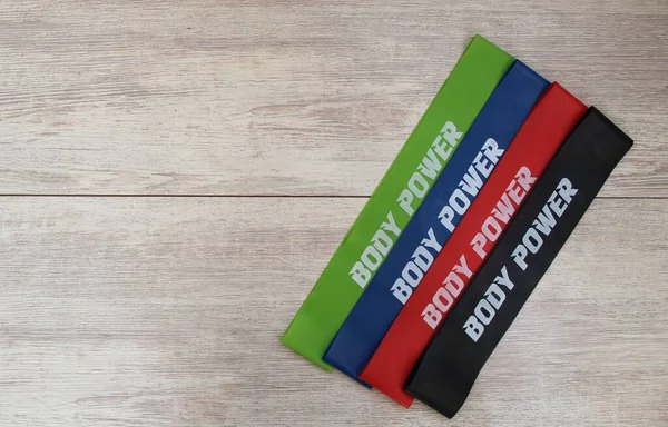 Beyaz arka planda fitness için renkli kauçuk bantlar. Spor konsepti. Evde spor yapma trendi. Üst görünüm, düz görünüm, kopyala boşluk, izole et.