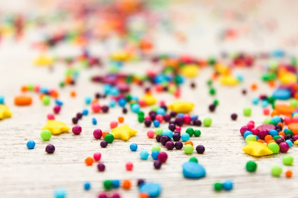 Beyaz ahşap zemin üzerine şeker serpiştirilmiş. Parlak renkler ve tatlı bir tat. Paskalya kreması için serp. Paskalya için hazırlanılıyor