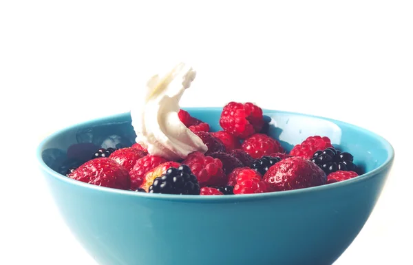 Different berries in a bowl with whipped cream — Stock Photo, Image