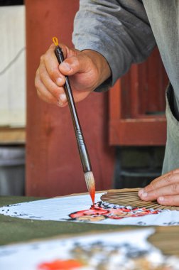 Budist keşiş haeinsa tapınağı gayasan milli parkı yakınlarında Güney Kore 'nin Gyeongsang eyaleti yakınlarında Çinli hayranlar tasarlayarak kaligrafi sanatını icra ediyor.