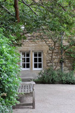 View of lawn and building facade with decorative planting from Hertford College Old Quad, Oxford, United Kingdom. Overcast Sky.