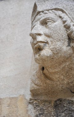Close-up of decorative stone head carving on wall of Bodleian library courtyard, Oxford, United Kingdom. Selective focus.