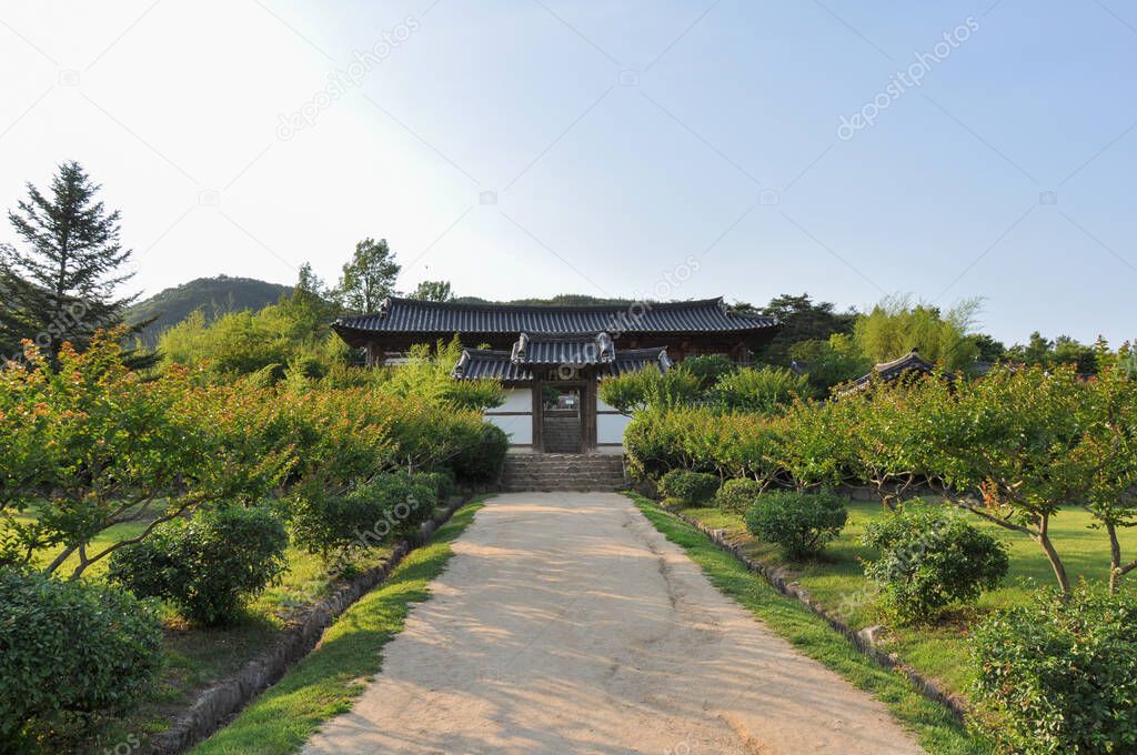 Korean Confucian Academy from Joseon Dynasty era. Path with small trees leading to main gate with pavilion behind. Byeongsan Seowon, Andong, South Korea. Translation: 