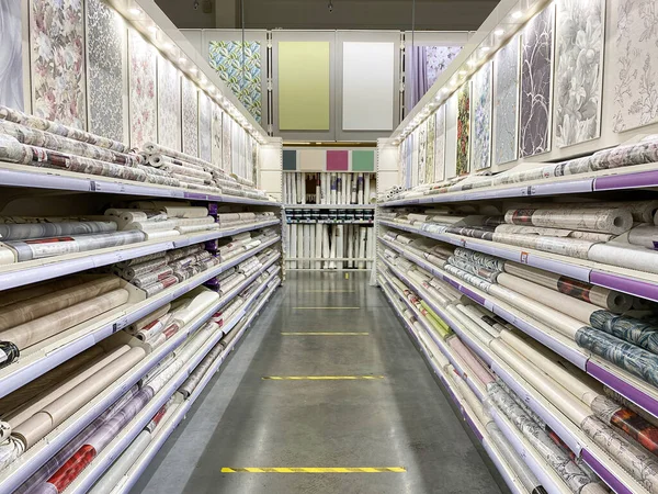 Shop wallpapers and building materials. Racks with wallpaper rolls