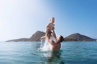 Baba ve oğul denizde oynuyorlar. Baba oğlunu fırlatır.. 