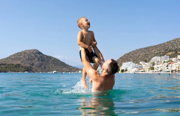 Baba ve oğul denizde oynuyorlar. Baba oğlunu fırlatır.. 