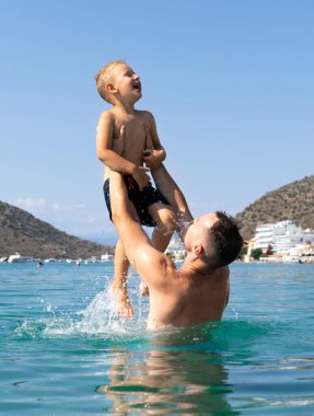 Baba ve oğul denizde oynuyorlar. Baba oğlunu fırlatır.. 