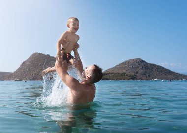 Baba ve oğul denizde oynuyorlar. Baba oğlunu fırlatır.. 